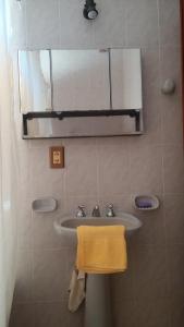 baño con lavabo, espejo y toalla en Apart Termal San Ramon en Termas de Río Hondo