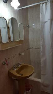 a bathroom with a sink and a shower with two mirrors at Apart Termal San Ramon in Termas de Río Hondo +9 photos