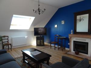 sala de estar con paredes azules y TV en Maison Gille, en Nuits-Saint-Georges