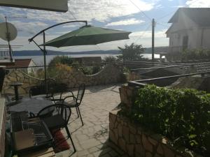 a patio with a table and chairs and an umbrella at Odvojak Apartments in Crikvenica