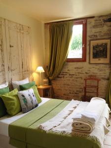 ein Schlafzimmer mit einem grünen Bett und einem Fenster in der Unterkunft Côté-Serein - Les chambres du Clos-Malo in Noyers-sur-Serein