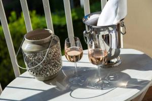 - une table avec deux verres de vin et un pitcher dans l'établissement Le Corot, à Beaulieu-sur-Mer