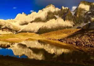 a reflection of a mountain in a body of water at Historic Residence Madonna in San Martino di Castrozza