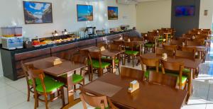 a restaurant with wooden tables and chairs and a counter at Velit Hotel in Teresina