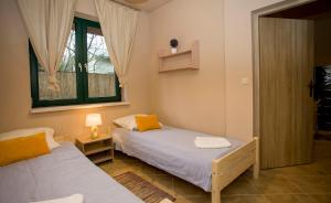 a bedroom with two beds and a window at Apartamenty Poddąbie in Poddąbie +11 photos