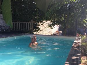 una persona nadando en una piscina en Côté-Serein - Les chambres du Clos-Malo en Noyers-sur-Serein
