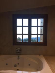 a bath tub in a bathroom with a window at Enthymio Suites in Synikia Mesi Trikalon