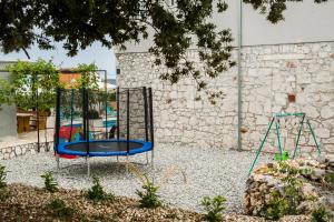 einen Spielplatz mit Schaukel im Hof in der Unterkunft Holiday Home Gabi in Rogoznica