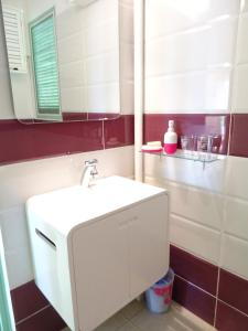 W łazience znajduje się biała umywalka i lustro. w obiekcie les hauts de caritan w mieście Sainte-Anne
