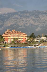 un grand bâtiment sur la rive d'une masse d'eau dans l'établissement Valeri Beach Hotel, à Kemer