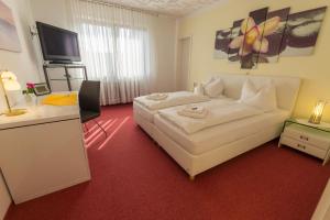 a hotel room with a white bed and a television at Hotel Rosengarten in Schwäbisch Gmünd