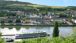 un grand bateau sur une rivière dans une ville dans l'établissement Pension Weber, à Wellen