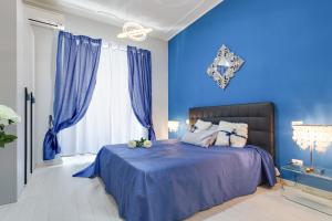 a blue bedroom with a bed with blue walls at Louise at Colosseum in Rome