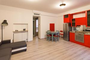 a kitchen and living room with red cabinets and a table at La Casa nel Borgo in Bergamo