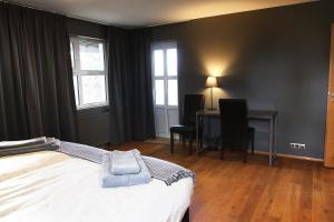 een slaapkamer met een bed, een bureau en ramen bij Ármót Guesthouse in Hvolsvöllur