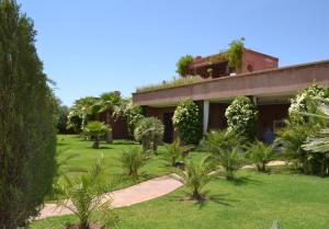 una casa con jardín y árboles delante de ella en Villa Jade, en Marrakech