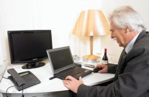 a man sitting at a desk with a laptop computer at Hotel Löwenguth in Montabaur