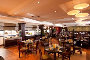 a restaurant with tables and chairs and a bar at Leonardo Inn Glasgow West End in Glasgow