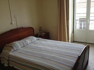 1 cama en un dormitorio con ventana y puerta en Verde Esperança, en Lisboa