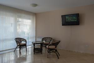 a waiting room with chairs and a tv on the wall at Guest House Donchevi in Primorsko