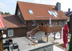 une grande maison avec une terrasse et une maison dans l'établissement Ferienhaus Brockenbäcker, à Tanne