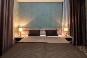 a bedroom with a large bed with two lamps at Old Side Boutique Hotel in Tbilisi City