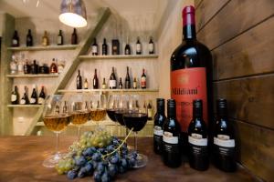 um monte de garrafas de vinho e copos de vinho em uma mesa em Old Side Boutique Hotel em Tbilisi