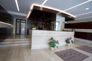 a lobby with a reception desk and potted plants at My Stay in Dnipro