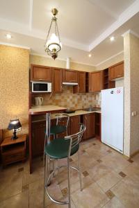 a kitchen with wooden cabinets and a white refrigerator at My Stay in Dnipro