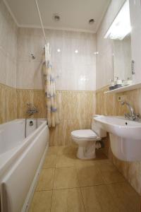 a bathroom with a sink and a toilet and a bath tub at My Stay in Dnipro