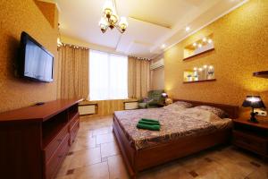 - une chambre avec un lit et une télévision à écran plat dans l'établissement My Stay, à Dnipro
