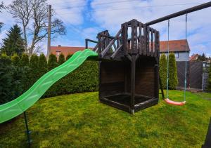 un parque infantil con un tobogán en un patio en Ferienhaus Brockenbäcker en Tanne