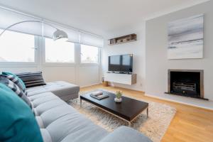 a living room with a couch and a fireplace at Holland Park 2 Bed Flat by BaseToGo in London