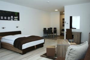 um quarto com uma cama, uma mesa e cadeiras em M&F Apartman em Egerszalók