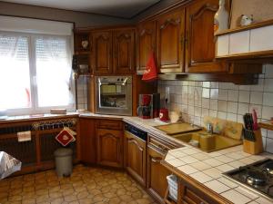 a kitchen with wooden cabinets and a stove top oven at La Petite Bresse in La Bresse