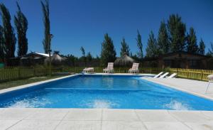 une piscine avec chaises et parasols dans l'établissement Cabañas Haras de Cuyo, à San Rafael 17 autres photos