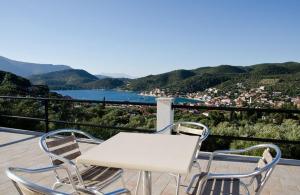 a white table and two chairs on a balcony with a view at Euktimeno in Vathi, Ithaka