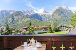 uma mesa numa varanda com vista para as montanhas em Appartements Millinger em Lofer