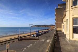 a street with cars parked next to the beach at Bayshore Hotel in Sandown