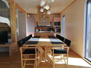 a dining room and kitchen with a wooden table and chairs at Saimaa Lotus Village in Imatra