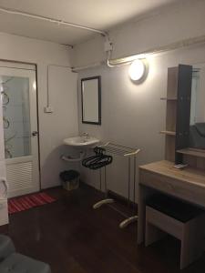 a bathroom with a sink and a table and a mirror at Bee Friend Hostel in Chiang Mai