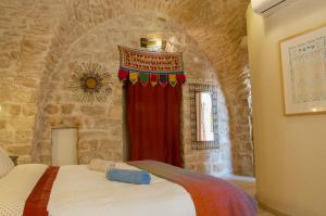 ein Schlafzimmer mit einem Bett und einem roten Vorhang in der Unterkunft Artist Quarter Guesthouse B&B in Safed