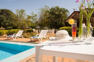 a white table with a hat on it next to a pool at Coesa Hoteis in Casa Branca
