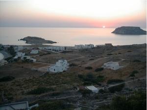 an island with white houses and the ocean with the sunset at Sea Melody in Lefkos Karpathou