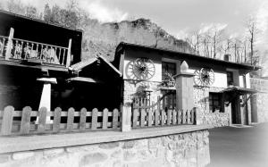 a black and white photo of a building with a clock at Apartamentos Rurales Villa-García in Corigos