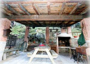 a patio with a table and an outdoor oven at Apartamentos Rurales Villa-García in Corigos