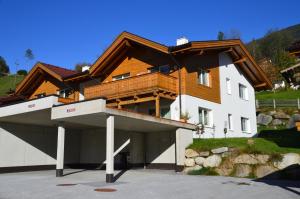 a house with a wooden roof and a garage at Haus Christine in Neukirchen am Großvenediger