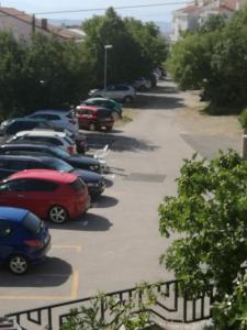 una fila de autos estacionados en un estacionamiento en Odvojak Apartments, en Crikvenica