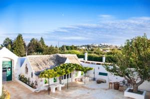une maison blanche avec un arbre devant dans l'établissement Masseria San Michele, à Martina Franca 130 autres photos