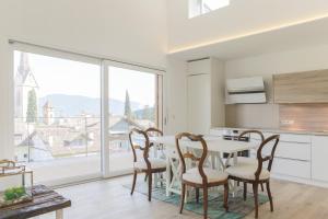 a kitchen with a table and chairs and a large window at Villa KaTo in Caldaro